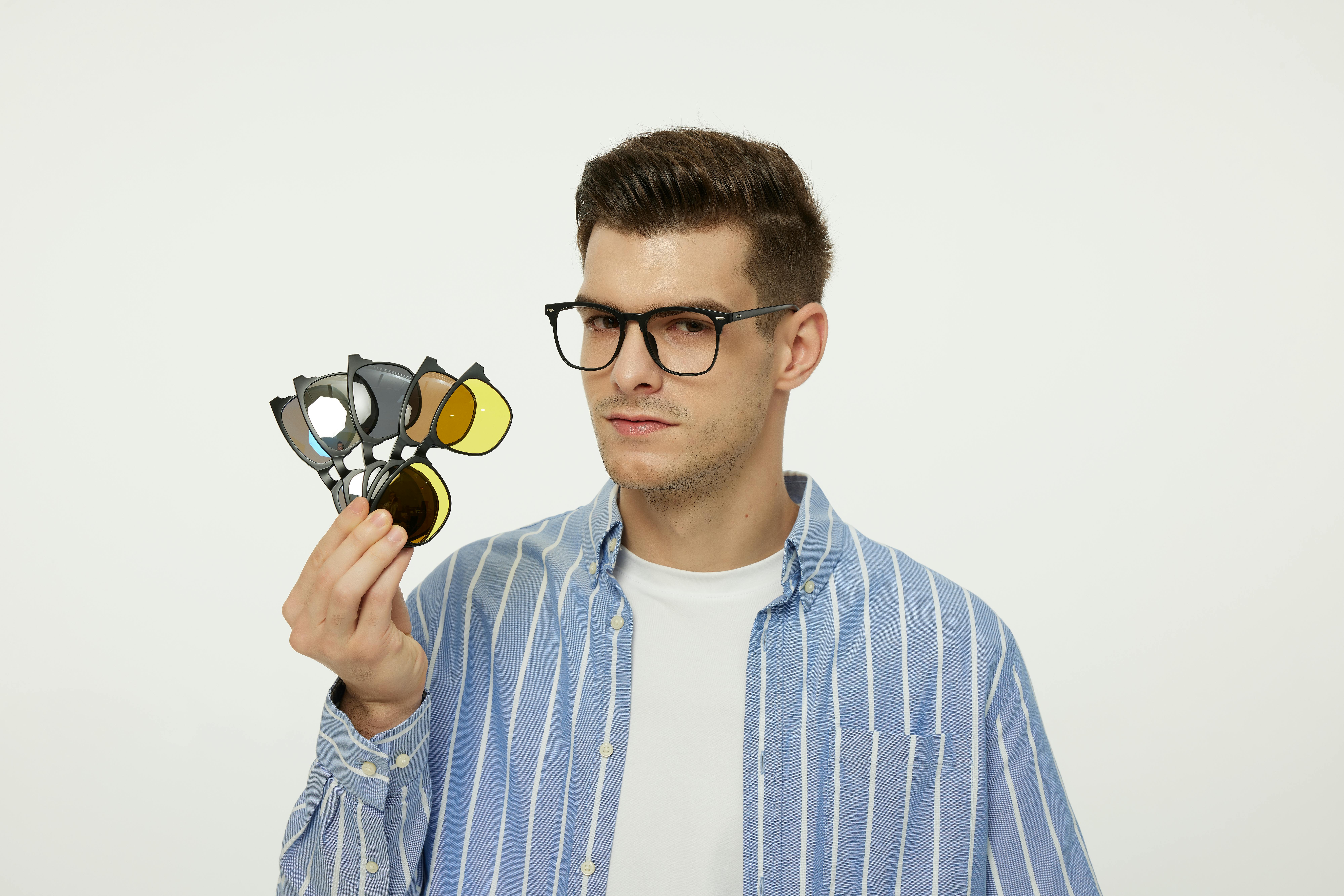 Free Young male model wearing glasses and a striped shirt, showcasing various eyewear lenses. Stock Photo