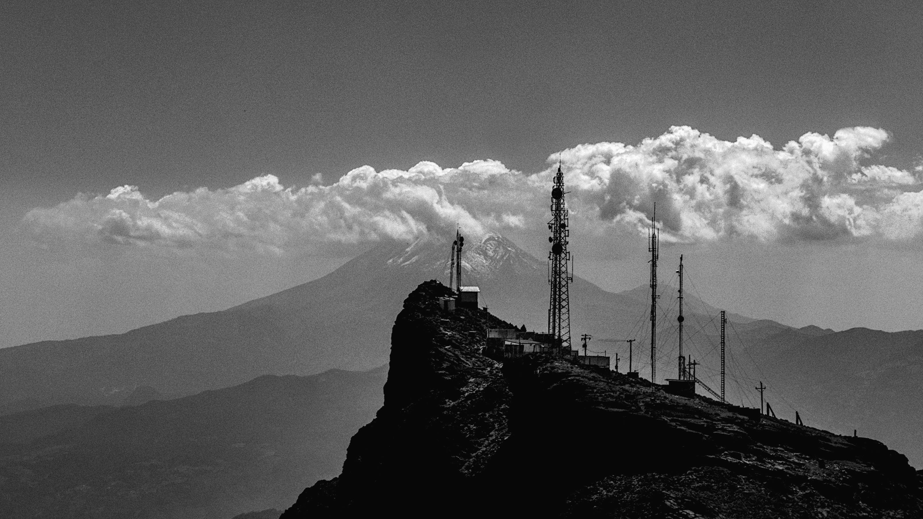 Explore the rugged beauty of Perote, Veracruz with antennas atop a mountain against a cloudy sky.