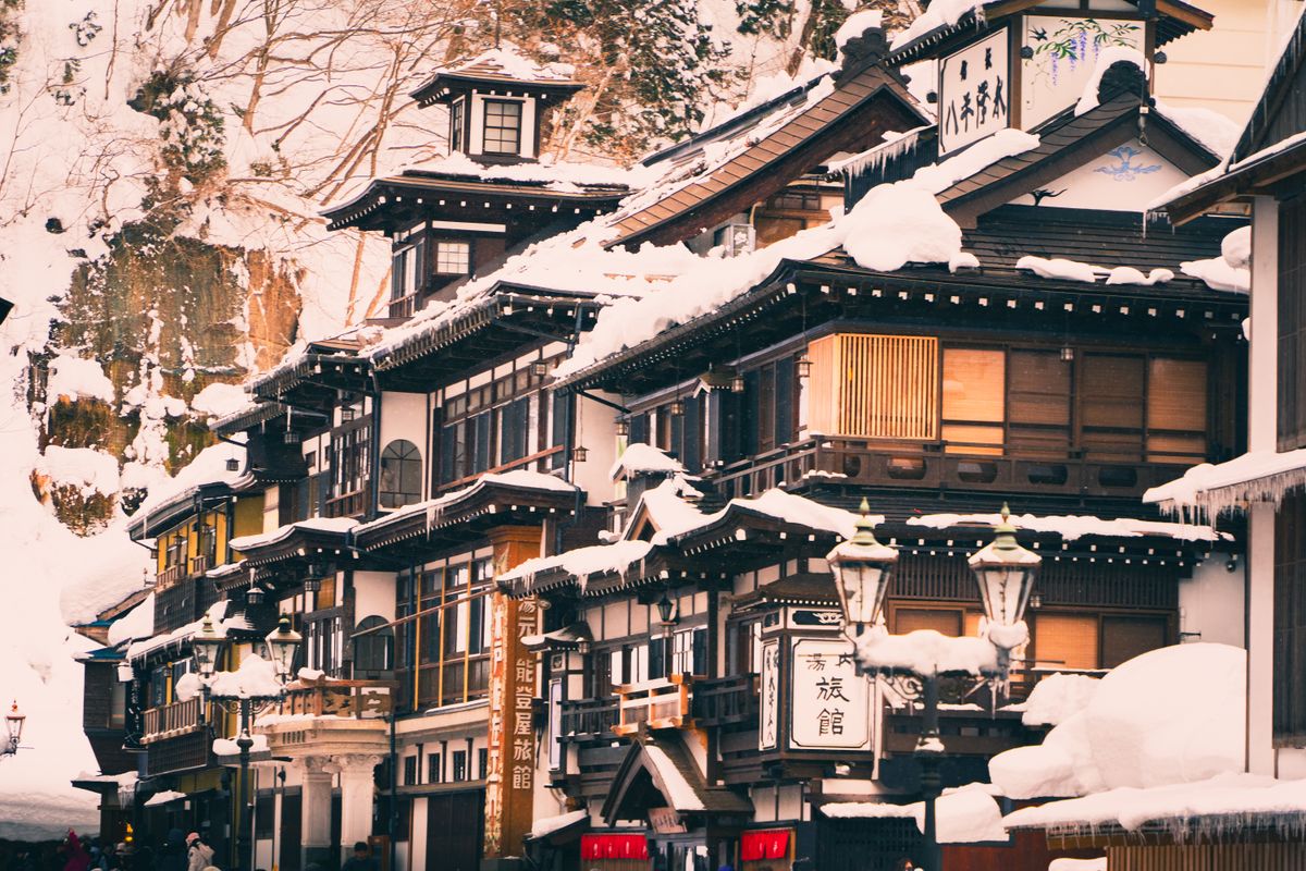 Traditional Japanese architecture under heavy winter snow — a snow-covered inn or teahouse in a mountain setting
