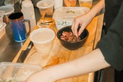 A chef arranging ingredients for a meal in a busy restaurant kitchen.