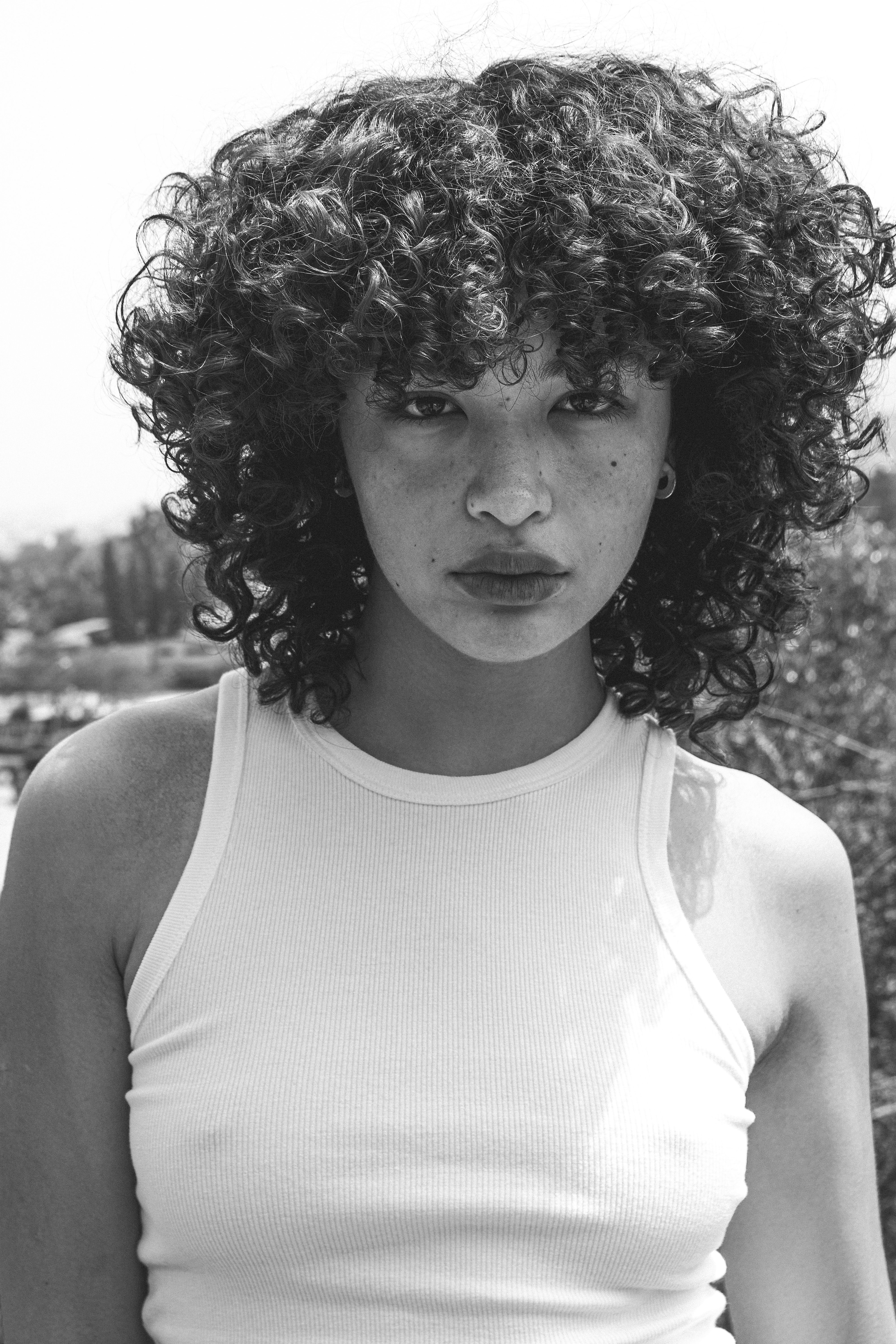Portrait of a woman with curly hair in black and white · Free Stock Photo