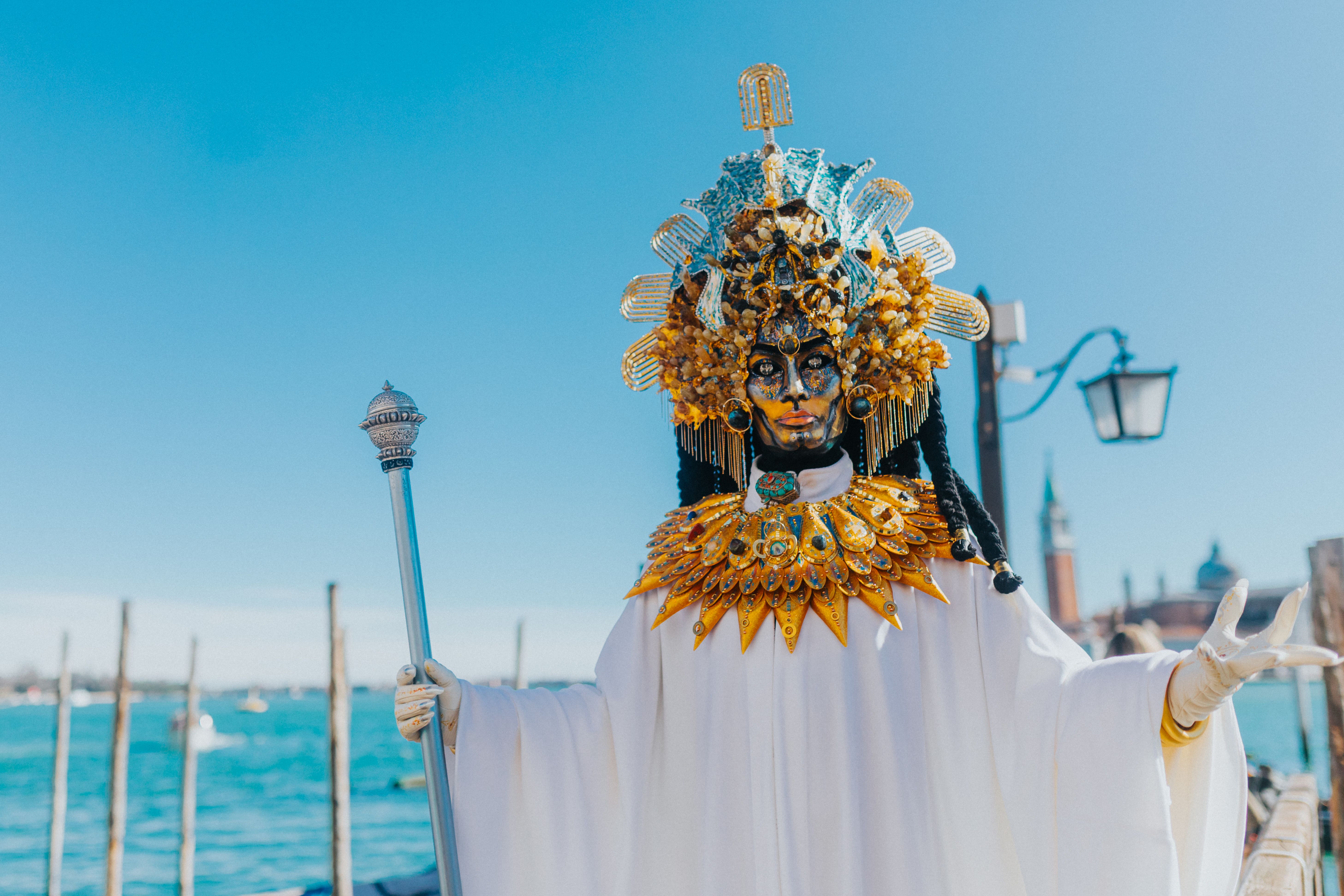 A detailed Venetian carnival costume with a dramatic mask set against a backdrop of Venice.