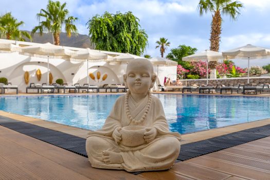 A serene Buddha statue overlooking a peaceful pool in a resort setting in Marmaris, Turkey.