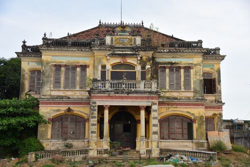 Free Aged colonial mansion with a weathered facade and overgrown vegetation adds an eerie charm. Stock Photo