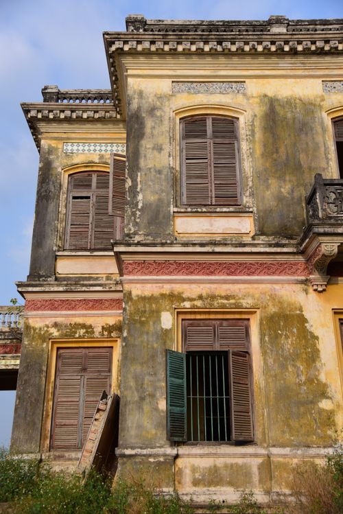 Free Weathered exterior of an abandoned French colonial building with shutters. Stock Photo