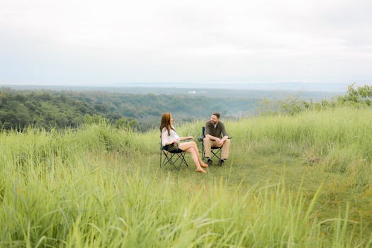 A couple enjoys a peaceful moment outdoors in Davao City amidst lush greenery and a scenic view.