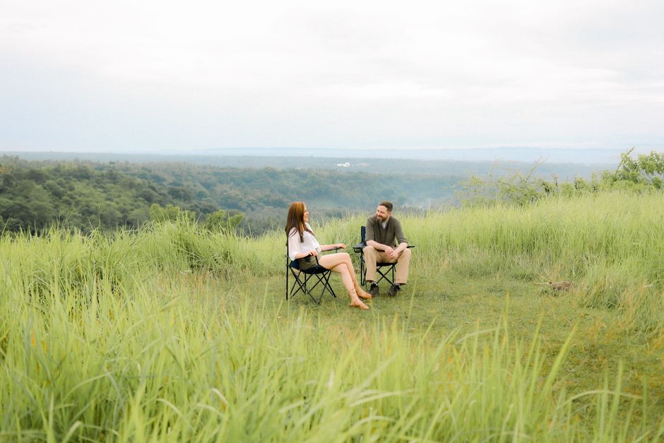 A couple enjoys a peaceful moment outdoors in Davao City amidst lush greenery and a scenic view.
