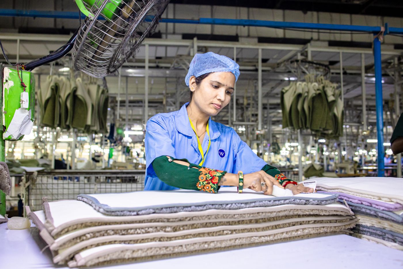 Textile worker inspecting fabric layers for quality