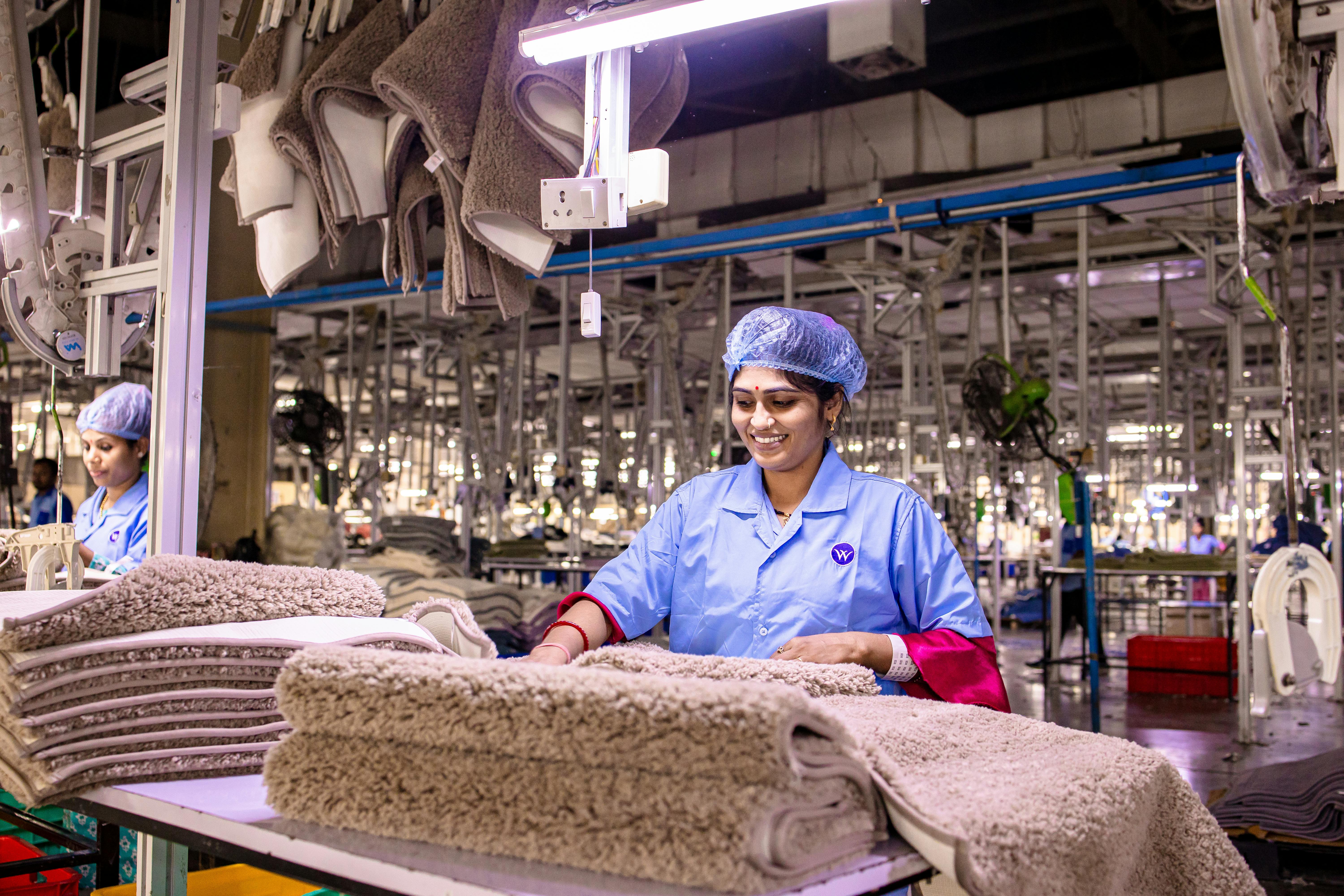 Happy female worker in a textile factory sorting fabric with precision and care.