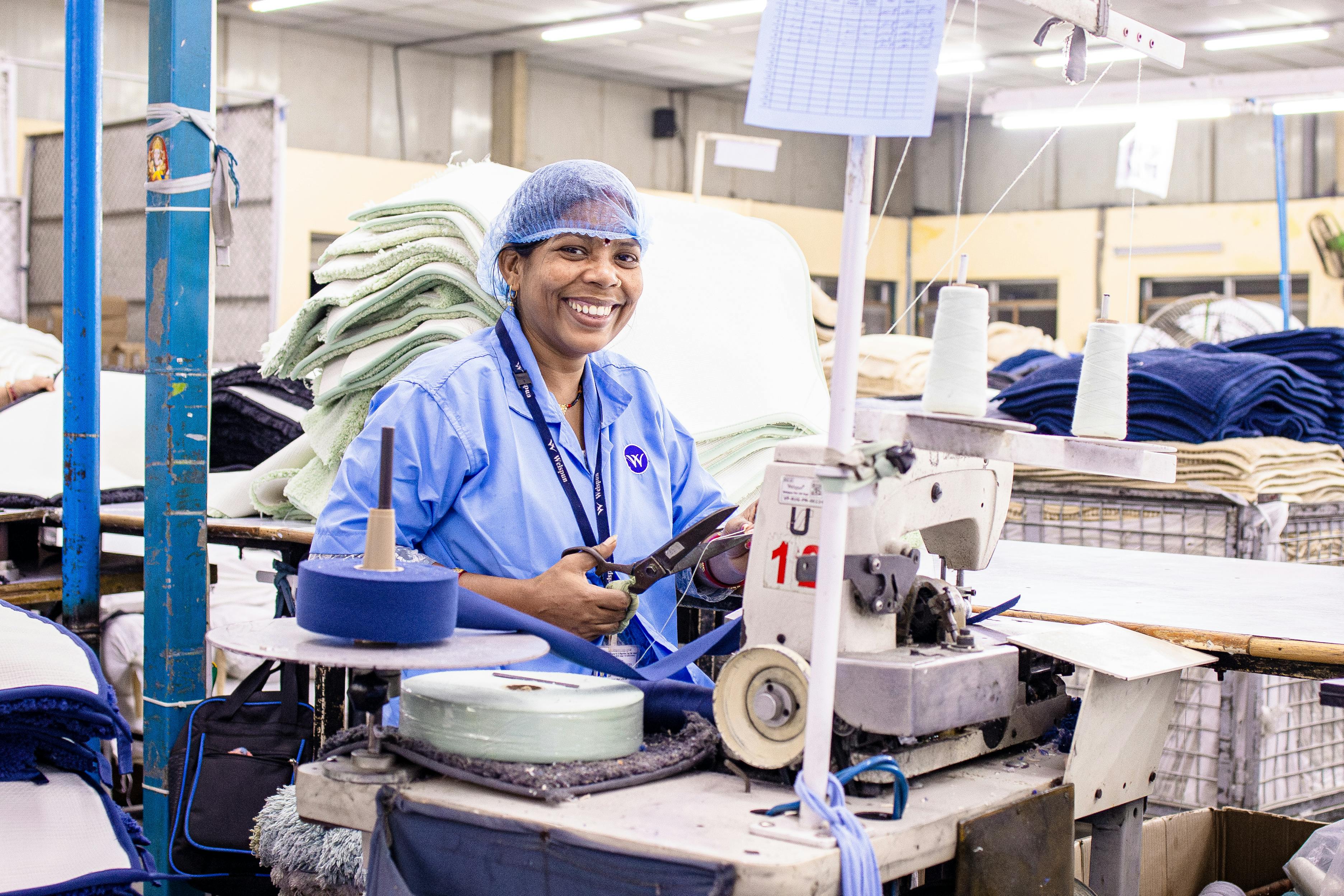 Smiling Female Textile Worker in Factory Setting · Free Stock Photo
