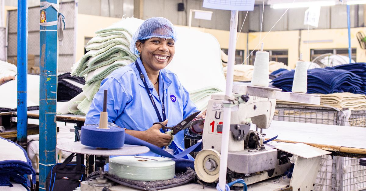 Smiling Female Textile Worker in Factory Setting · Free Stock Photo