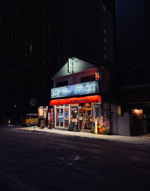 Free Dimly lit street scene featuring a cozy Asian restaurant at night. Stock Photo