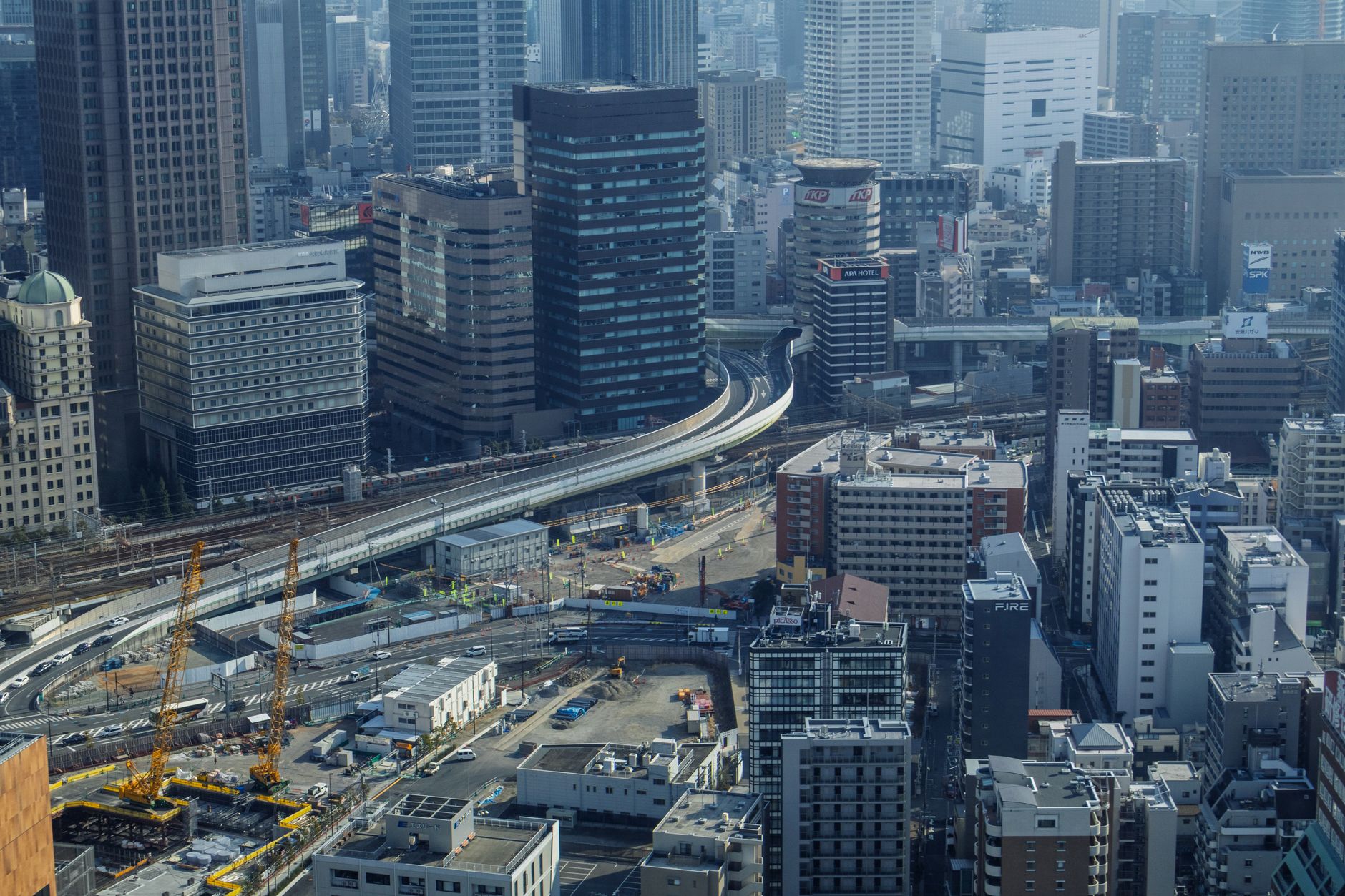 Aerial view of Osaka's urban landscape featuring a modern skyline and elevated highways.
