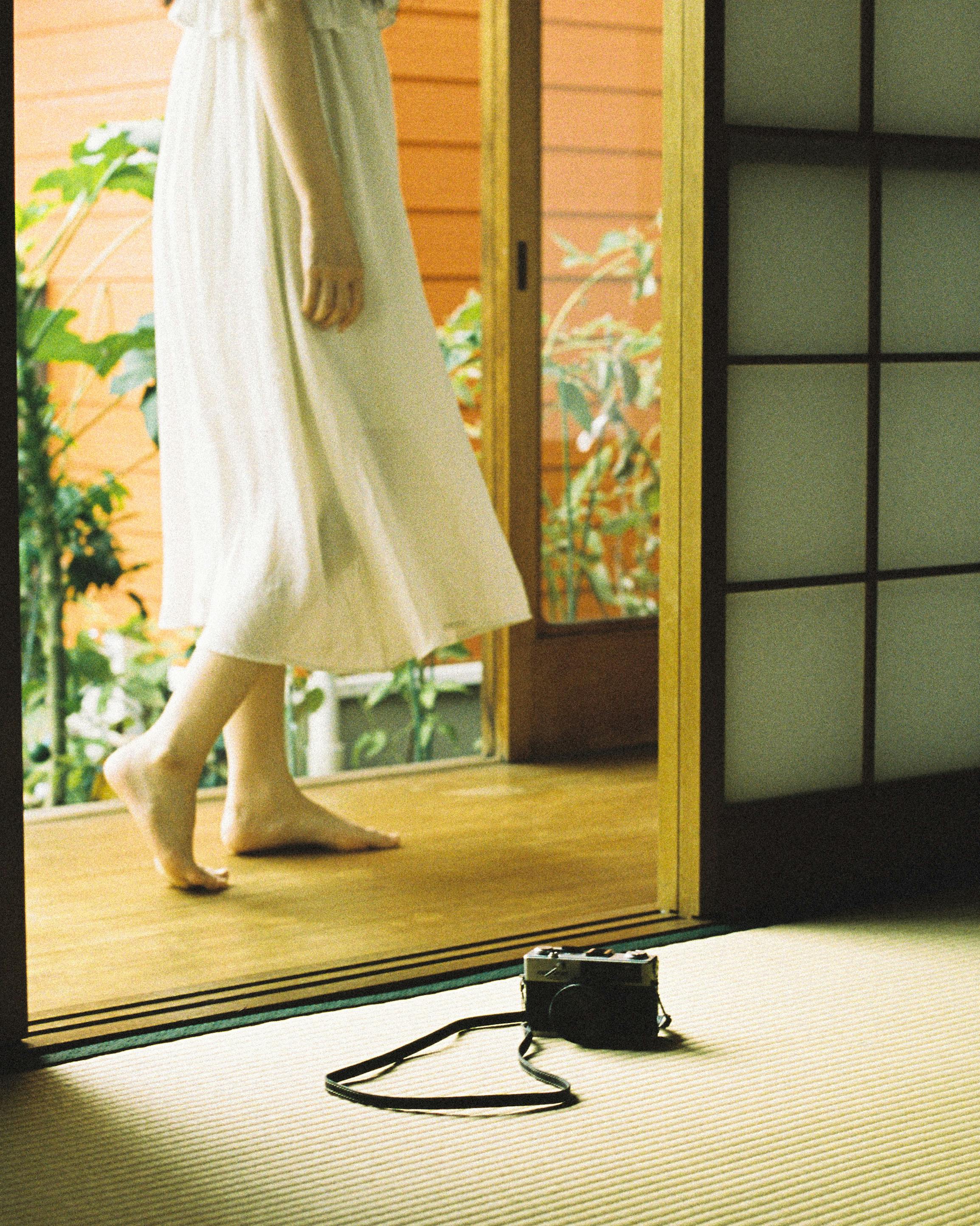 Serene scene of a woman in a flowing white dress inside a traditional room.