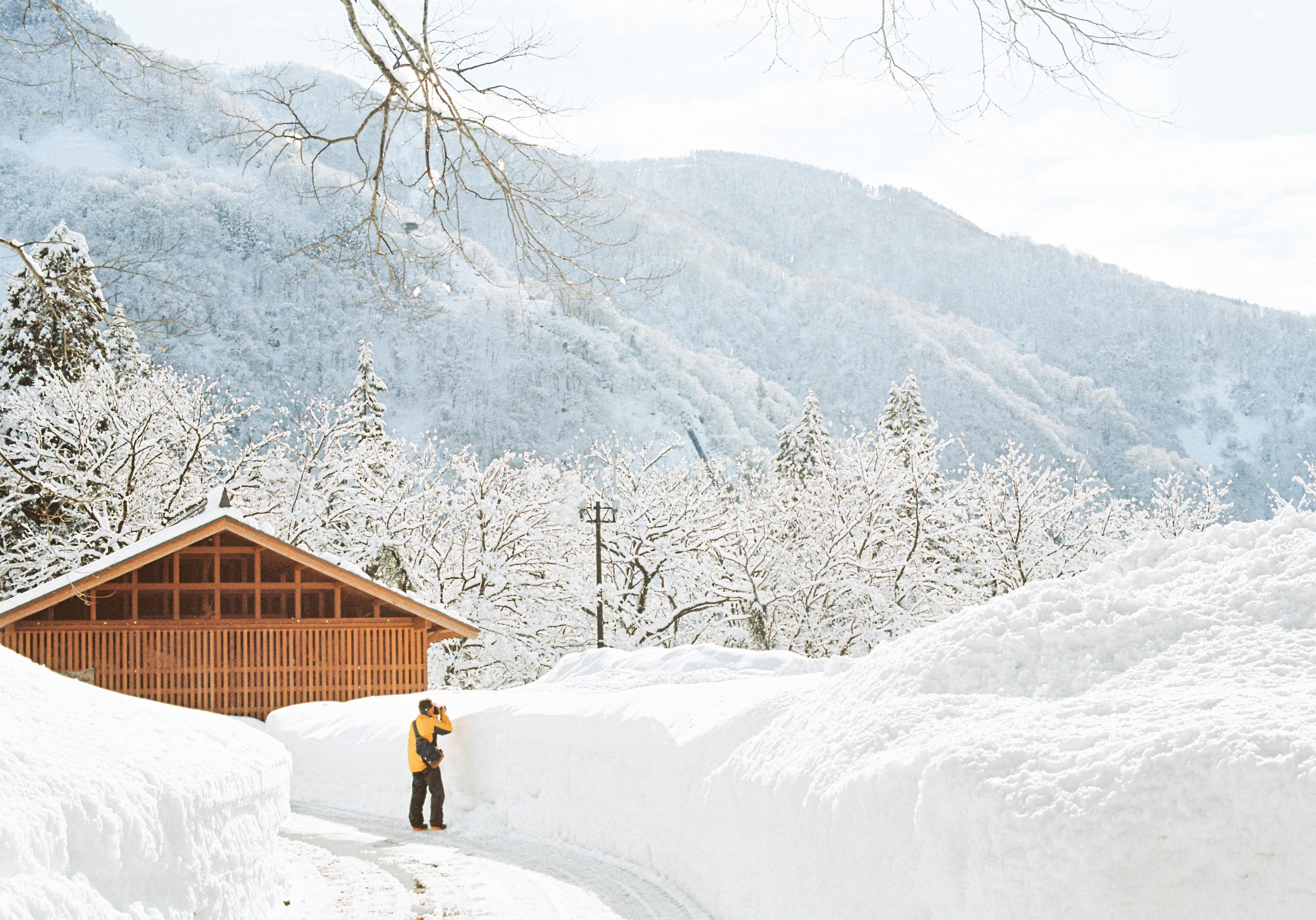 Idyllic snowy scene with a cabin and mountains in winter.