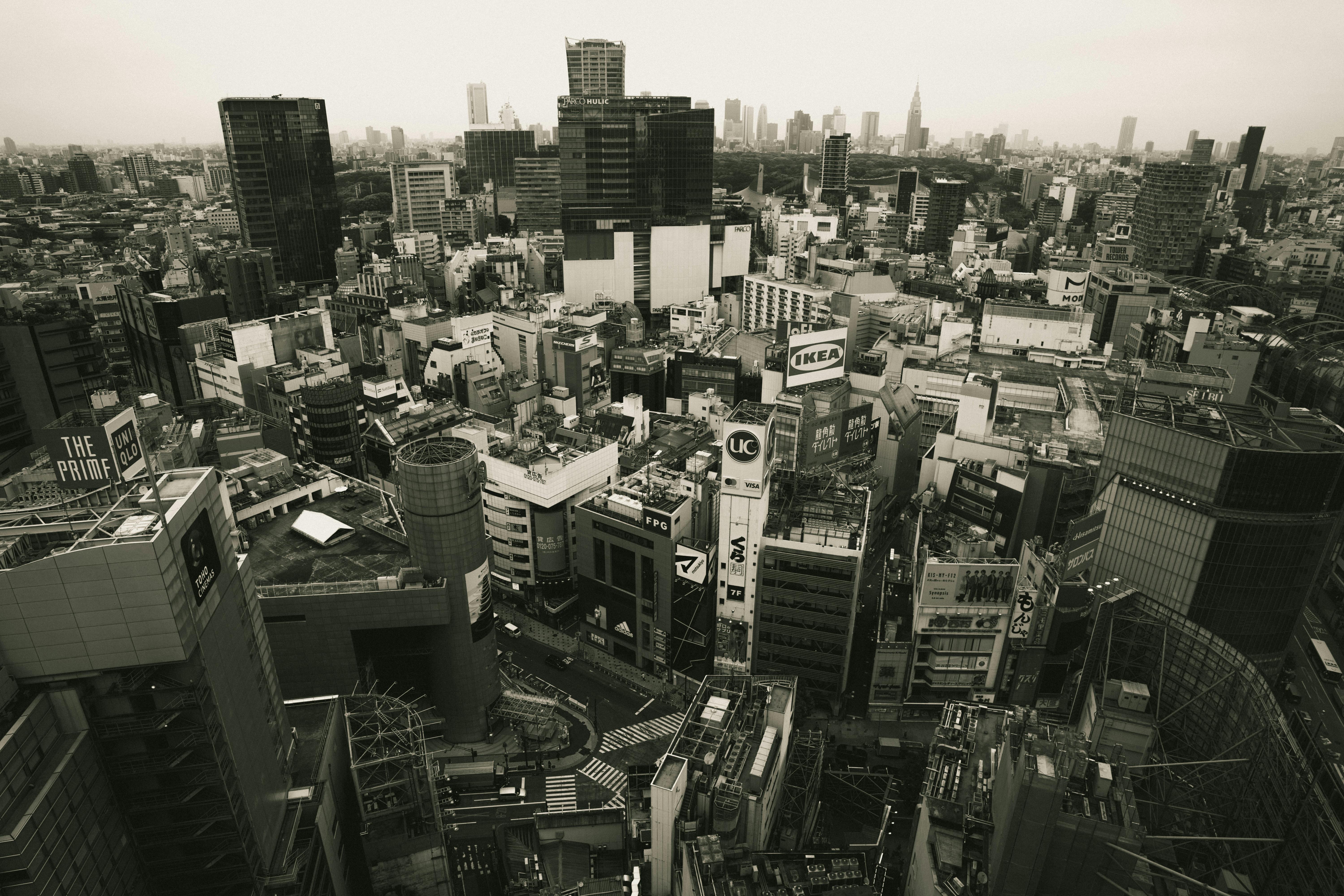 Dramatic black and white aerial view of Tokyo's urban landscape, showcasing iconic architecture and bustling city life.