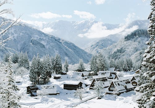 Idyllic winter scene of a snowy village nestled in mountain scenery.