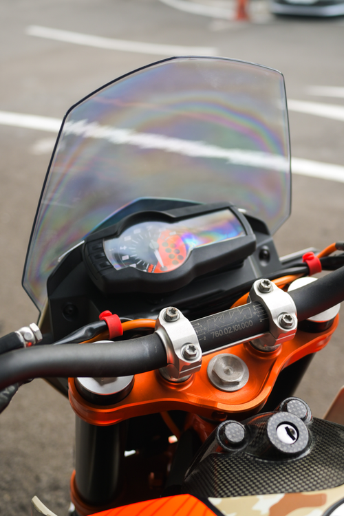 Free Vibrant orange motorcycle handlebar and dashboard with racing elements. Stock Photo