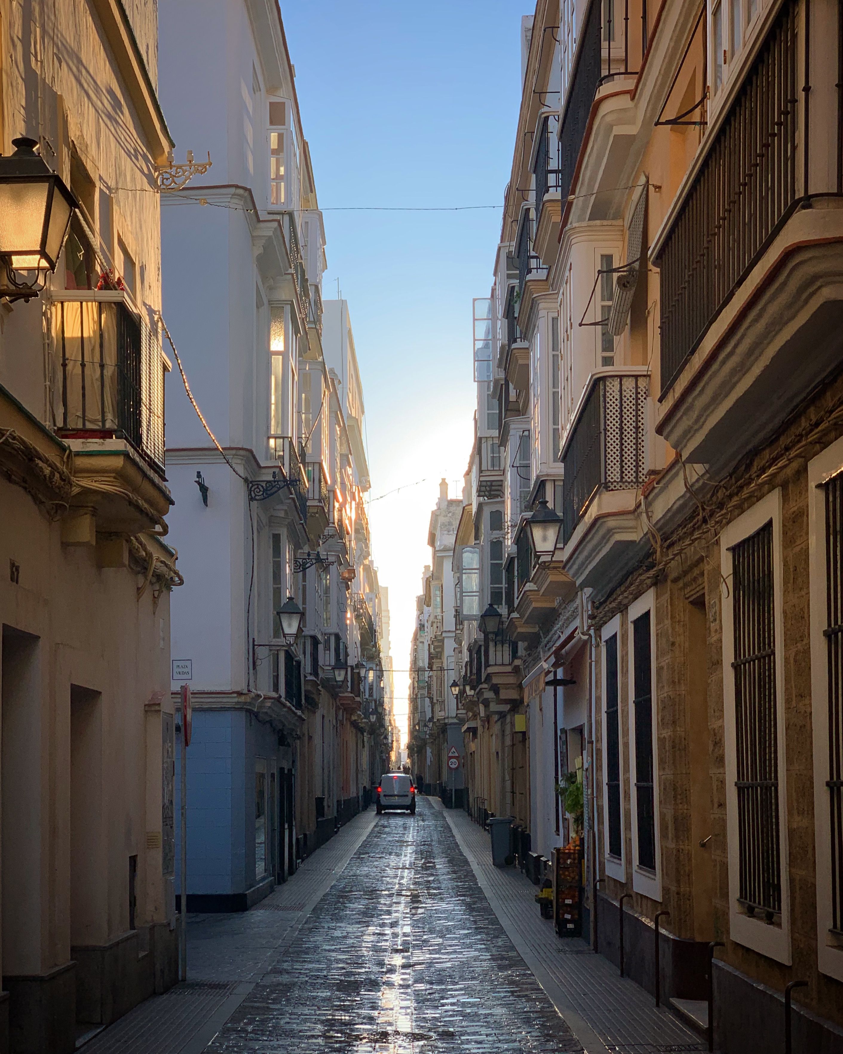 Gratis Esplora l'affascinante stradina di Cadice, in Spagna, con la sua architettura storica e le tonalità dorate del tramonto. Foto a disposizione
