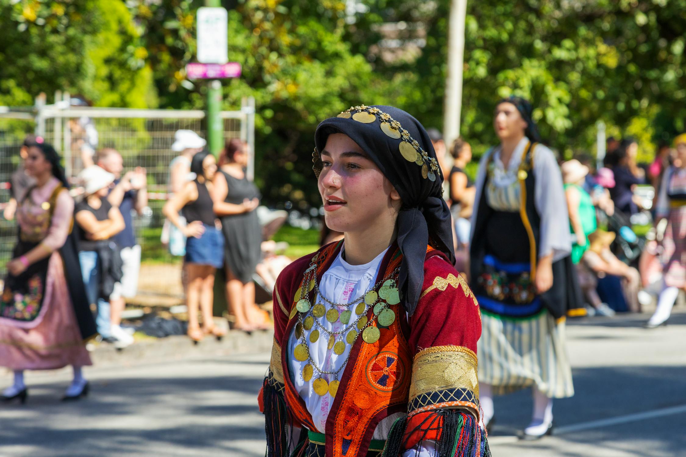 Woman in Traditional Greek Attire Celebrates Cultural Parade