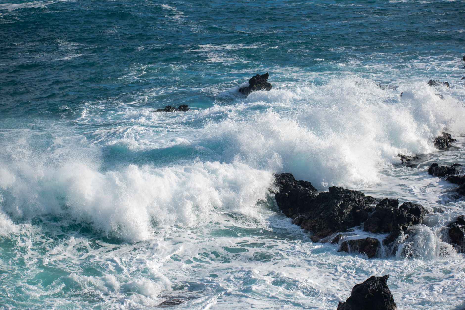 Powerful ocean waves crashing onto volcanic rocks in Canarias, Spain's coast.