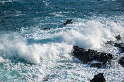 Powerful ocean waves crashing onto volcanic rocks in Canarias, Spain's coast.