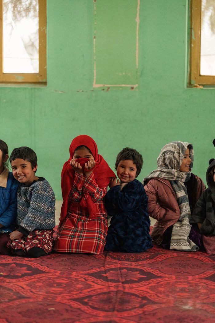 Afghan children seated together in a supportive community space