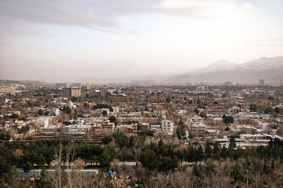 A sweeping aerial view of Kabul, Afghanistan showcasing urban landscape against mountainous backdrop.
