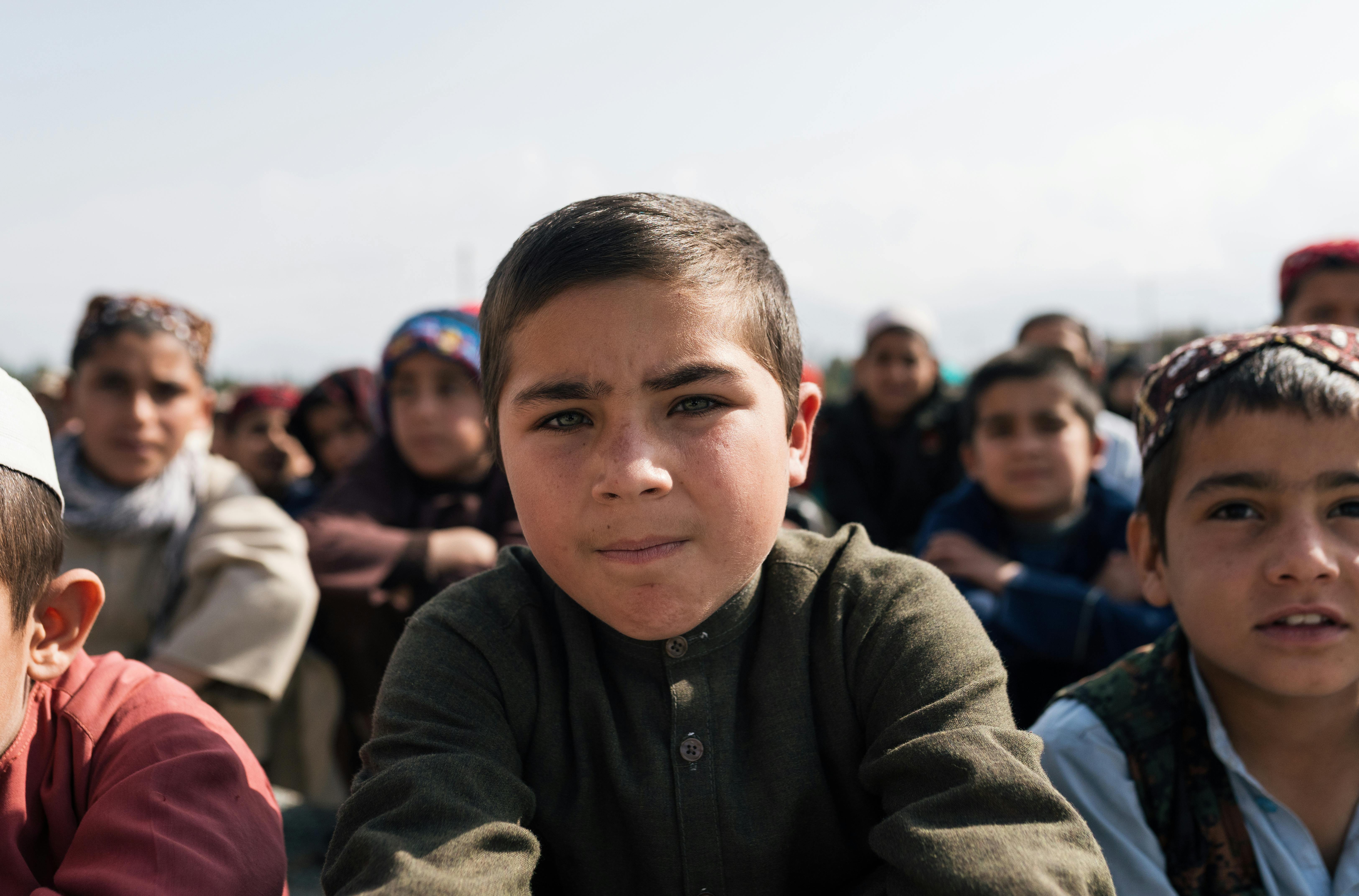 A group of children outdoors in Afghanistan, captured during the day.