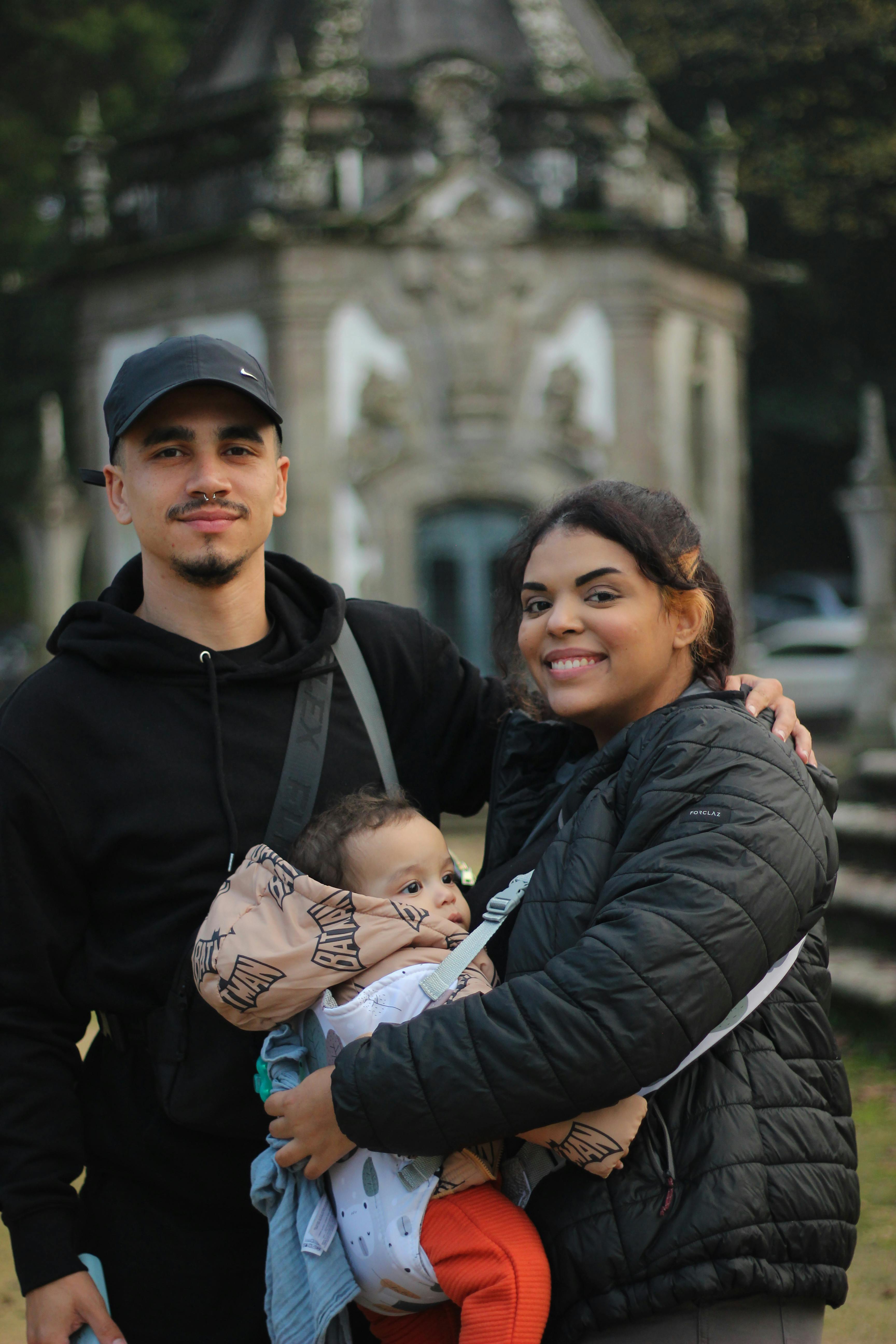 A joyful family enjoys a day out in a historic Braga park with charming architecture.