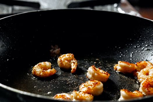Close-up of perfectly seared shrimp in a frying pan highlighting culinary skills.