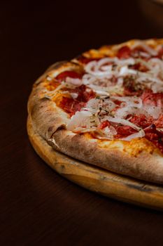 Close-up of a delicious homemade pizza with rich toppings on a wooden surface.