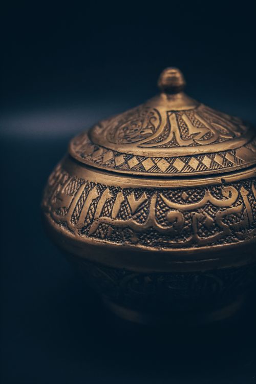 Free Close-up of a detailed brass box adorned with intricate Arabic calligraphy and patterns. Stock Photo