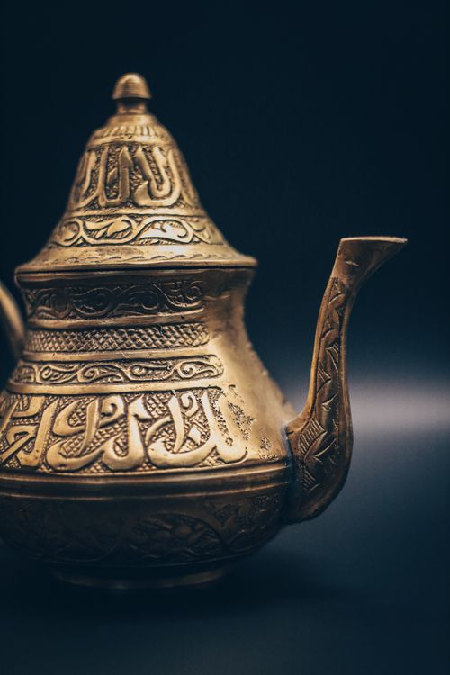 Free Close-up of an intricate brass teapot featuring Arabic calligraphy, showcasing traditional craftsmanship. Stock Photo