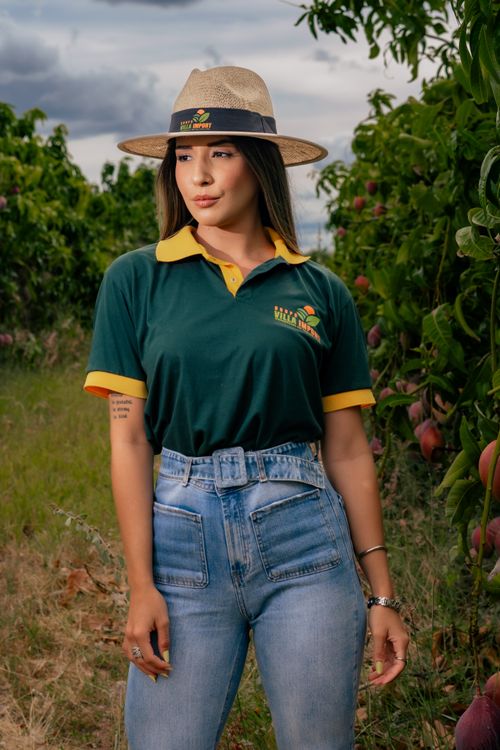 Free Woman in stylish hat and polo shirt standing in a fruit orchard. Stock Photo