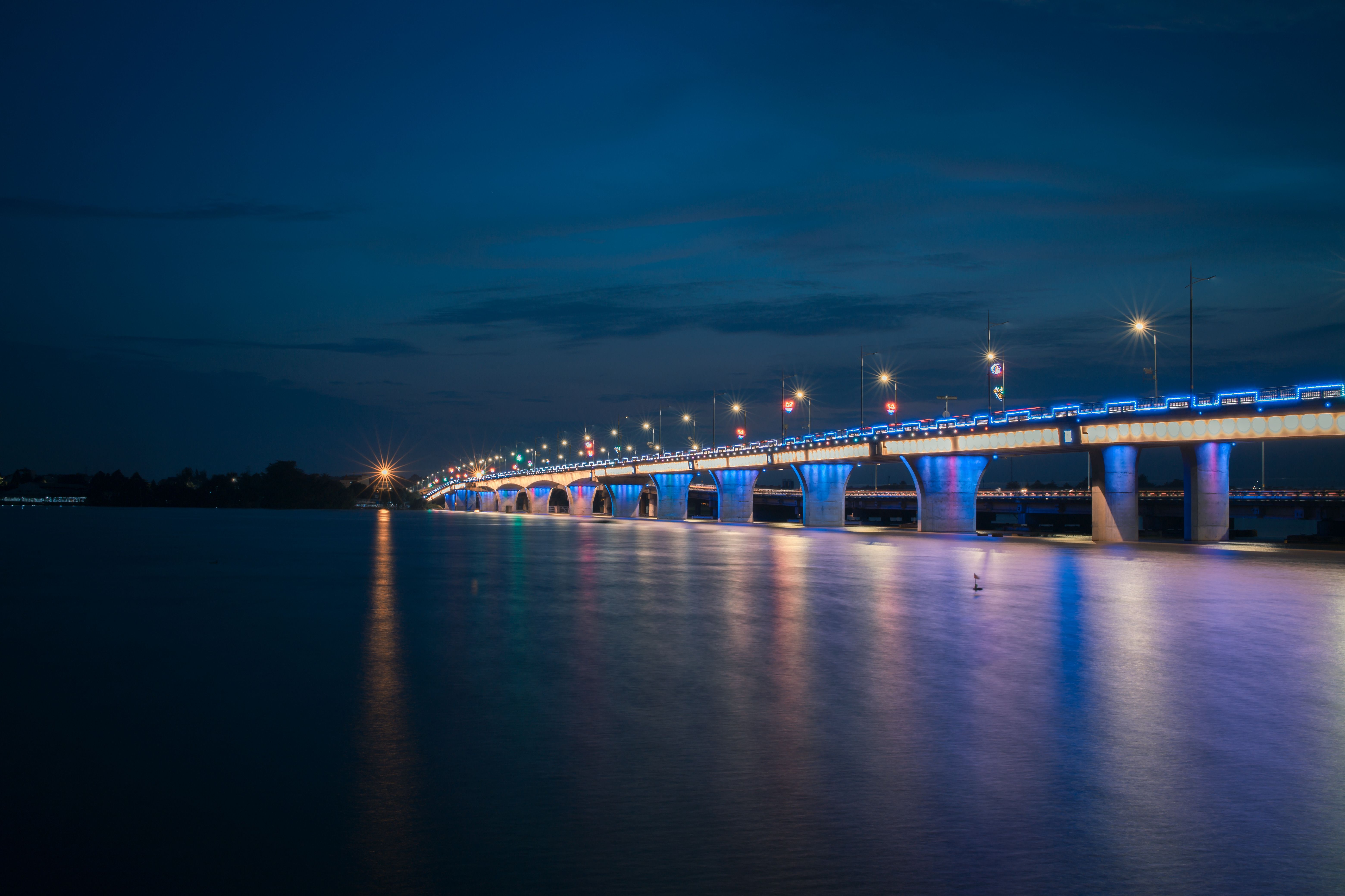 Illuminated Bridge Over Calm Water at Night · Free Stock Photo