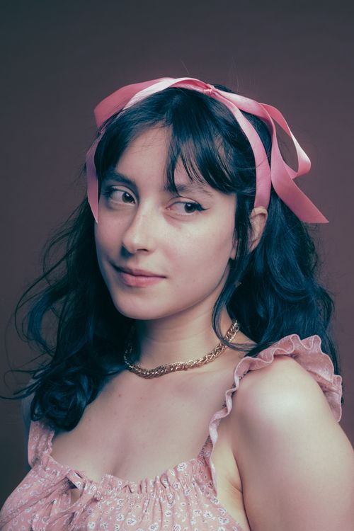 Free Chic portrait of a young woman in a pink dress and ribbon, showcasing elegance and fashion. Stock Photo