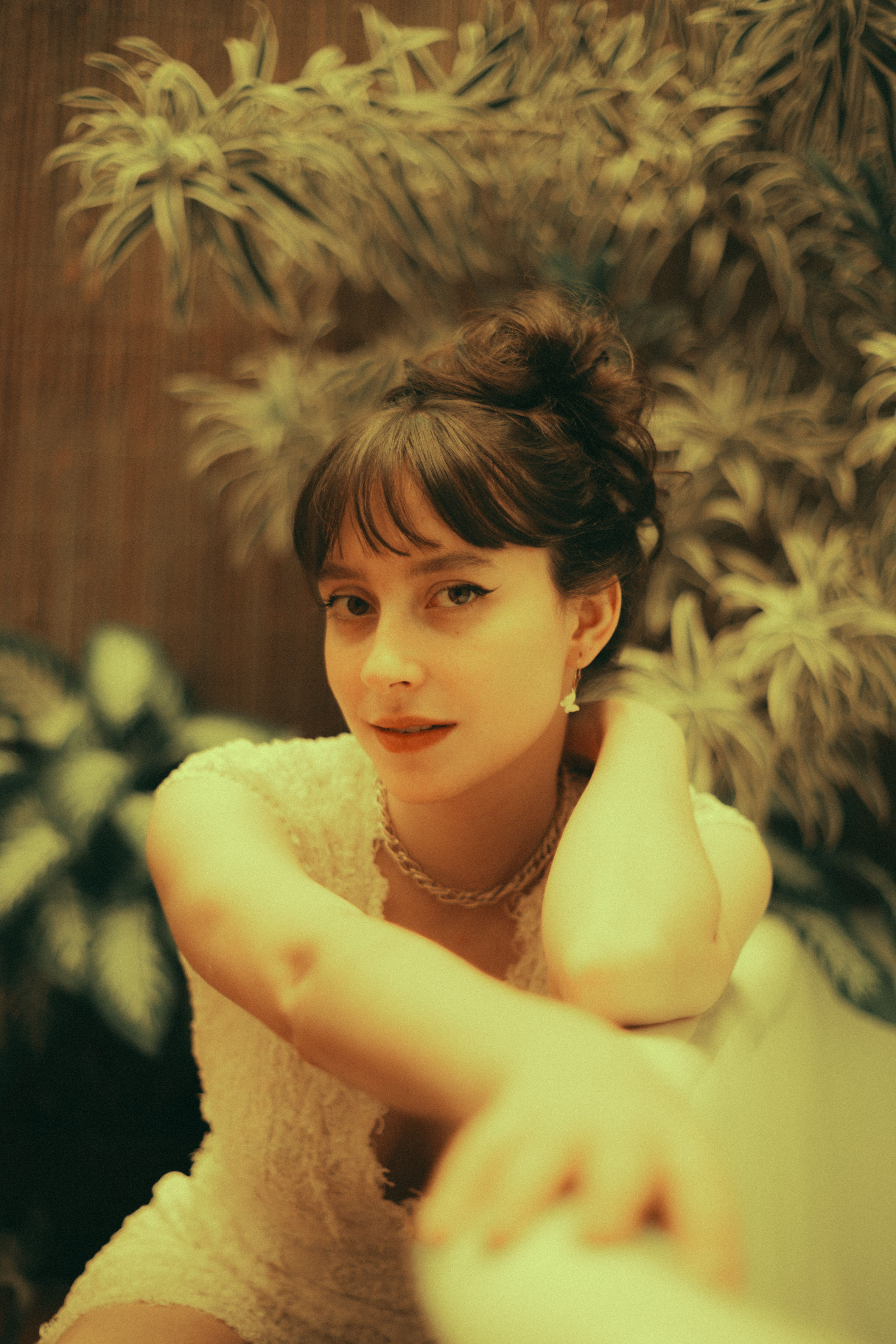 Elegant vintage portrait of a woman indoors with muted tones and warm lighting.