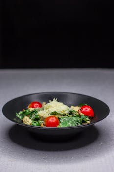 A vibrant salad featuring fresh greens, cherry tomatoes, and shredded cheese, perfect for a healthy meal.