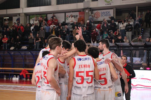 Basketball team huddles during a game in Imola. Capturing teamwork and dynamics.