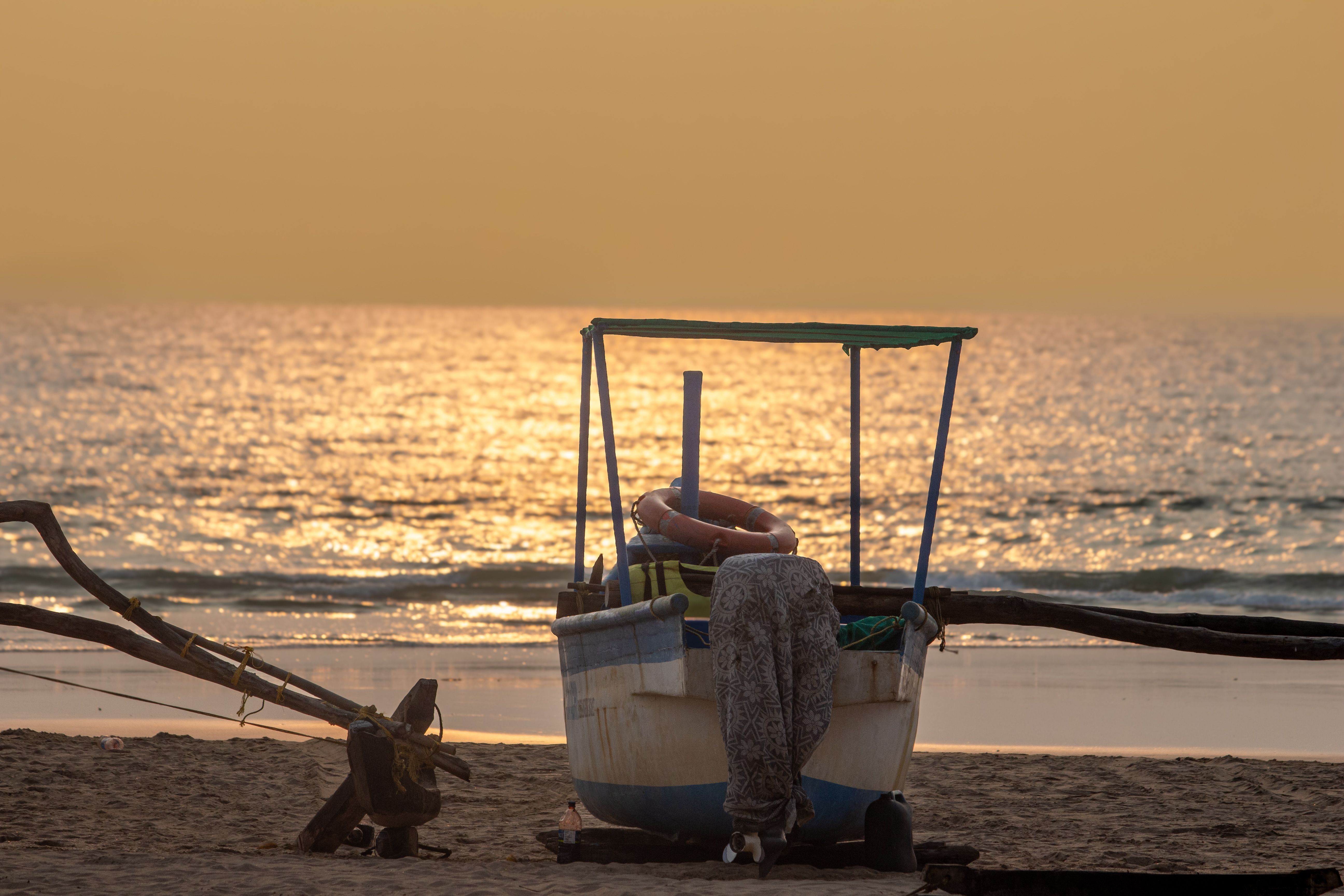 Fishing boat on a serene golden sunset beach · Free Stock Photo