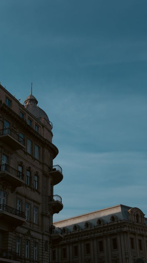 Free A detailed view of classic European architectural buildings against a clear blue sky. Stock Photo