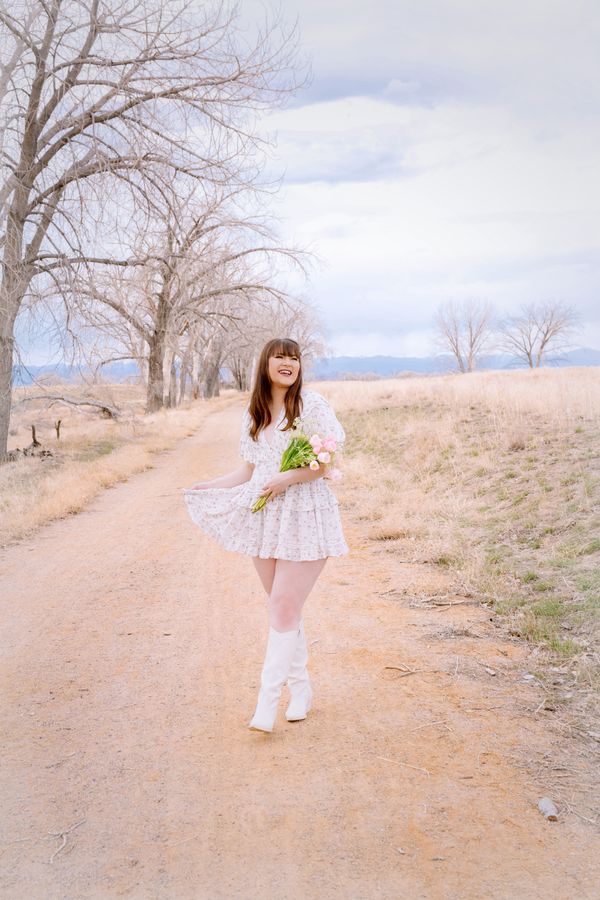 Woman in a light floral maxi dress with a straw hat