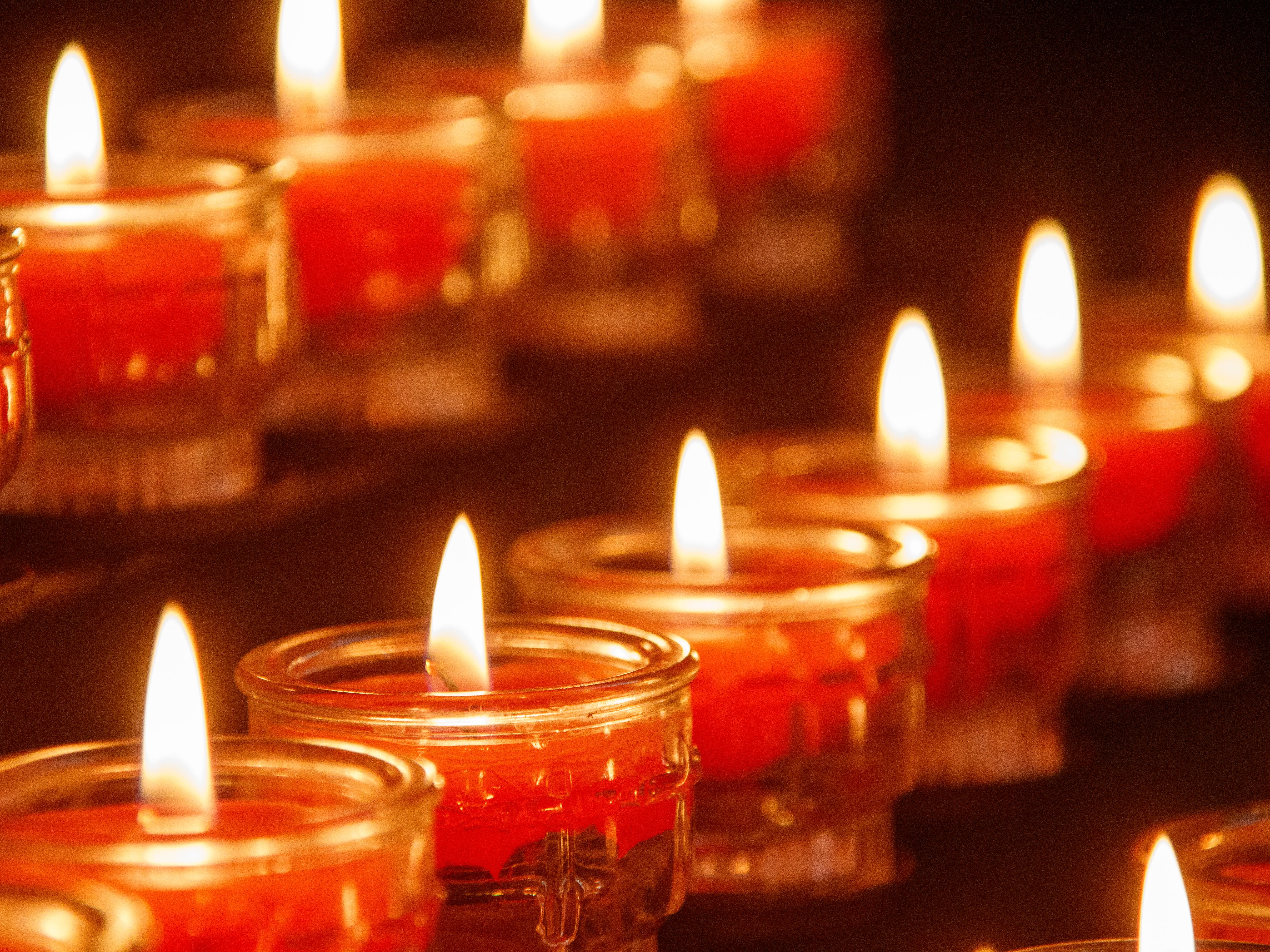 Warm and calming image of red votive candles glowing in a row, creating a serene ambiance.