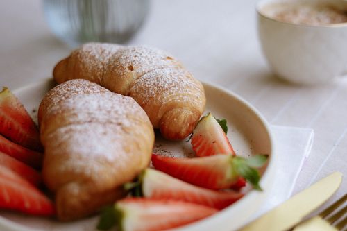 Free Appetizing breakfast with croissants and strawberries on a white plate. Stock Photo