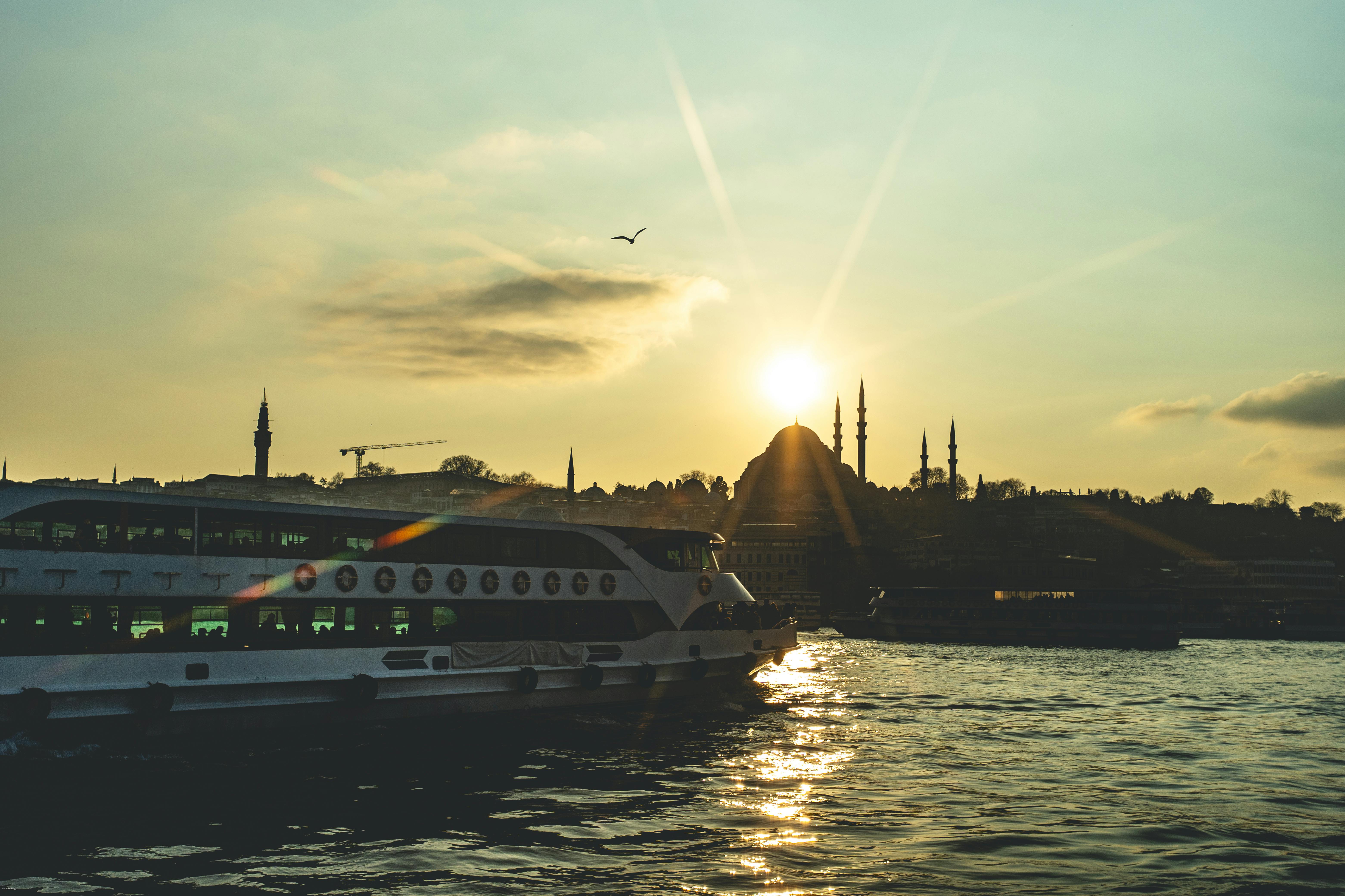 Gratuit Ferry glissant sur la Corne d'Or lors d'un magnifique coucher de soleil à Istanbul, silhouettes de mosquées visibles. Photos