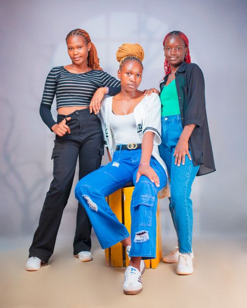 Free Three young women pose confidently in a studio setting, showcasing vibrant fashion and style. Stock Photo