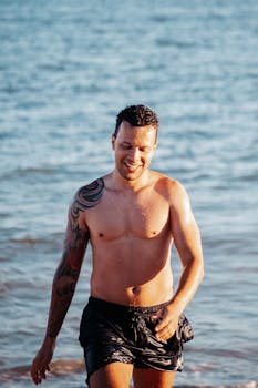 Happy man with tattoo enjoys sunny day at Porto Seguro beach in Brazil.