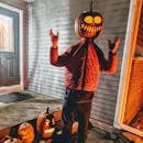 南瓜灯旁，戴着南瓜头的场景令人毛骨悚然