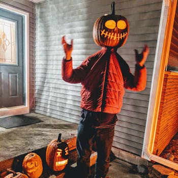 南瓜灯旁，戴着南瓜头的场景令人毛骨悚然